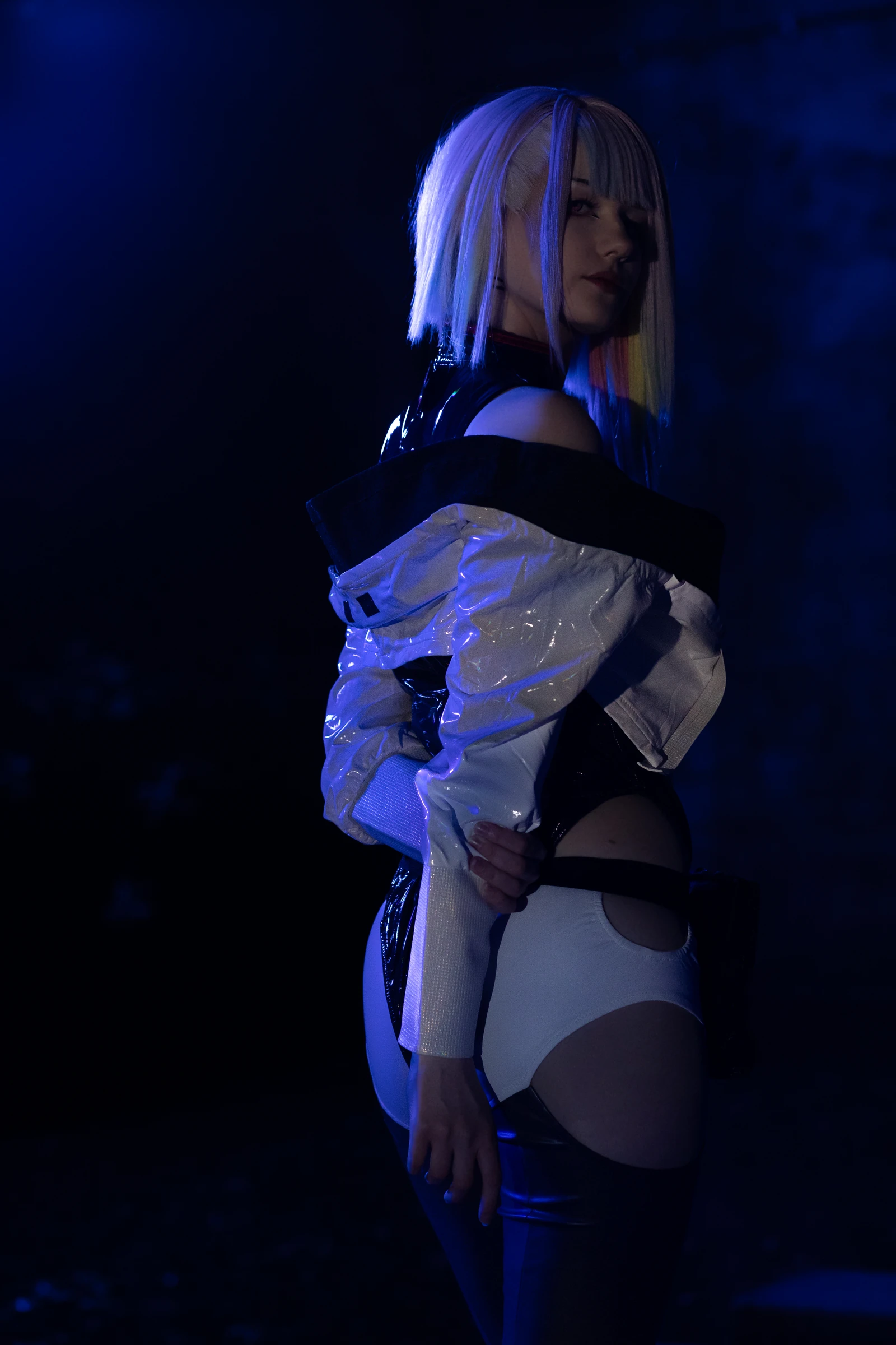 Cosplayerin mit weißer Jacke im blauen Licht