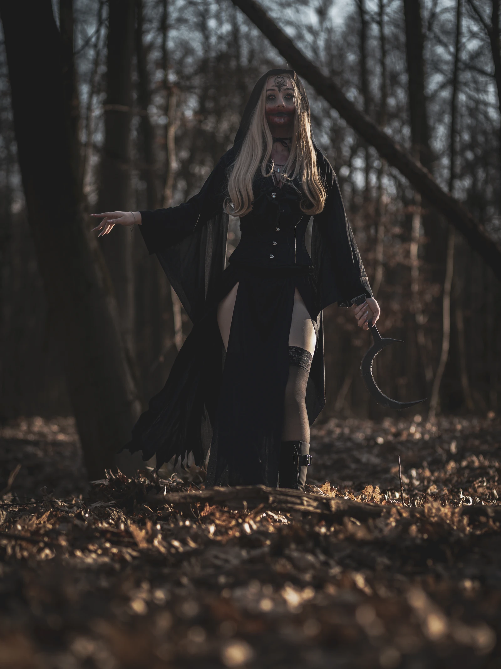 Dunkles Fantasy-Cosplay im Wald zwischen Baumstämmen